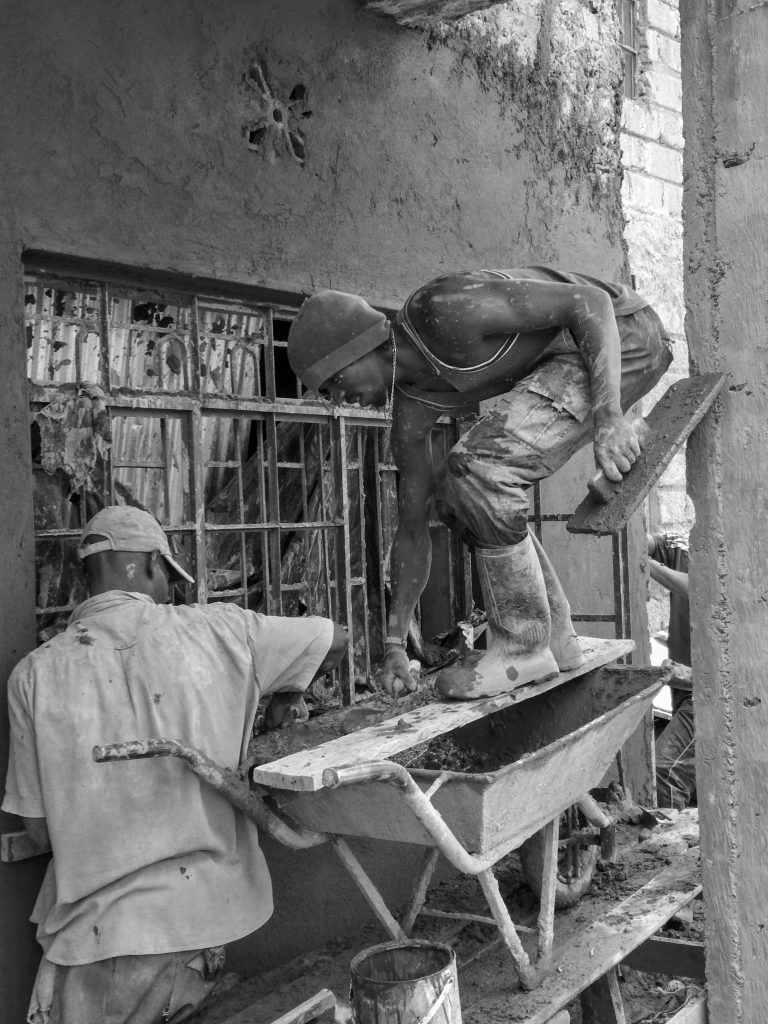 Construction workers building a residential house on-site, illustrating home builder operations that must connect sales CRM data to job costing.