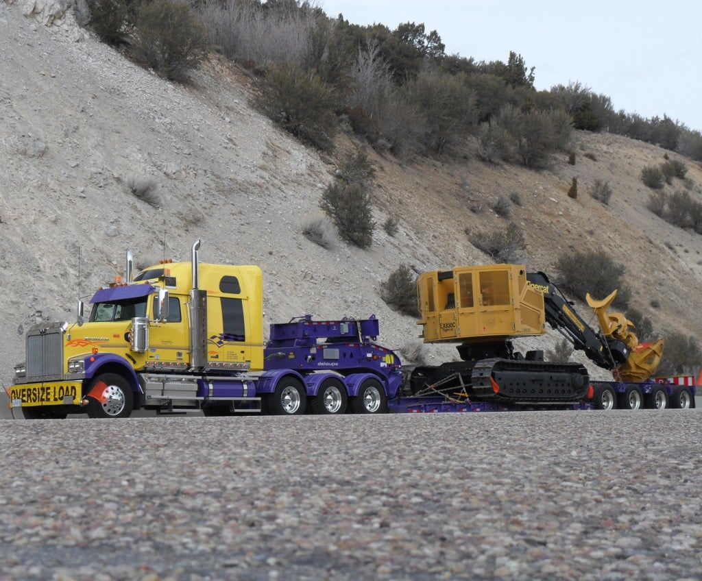 A Western Star semi-trailer tractor hauling an oversized load on a flatbed low loader, illustrating freight and logistics transportation operations.